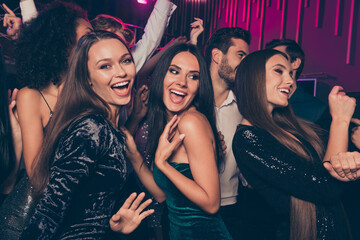 Photo of cheerful laughing happy beautiful girls wearing fashionable dress dancing at party in night club together celebrating new year with friends - obrazy, fototapety, plakaty
