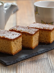 Three pieces of cake and a cup of tea over a wooden table