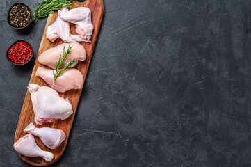 Fresh raw chicken meat and chicken parts. Black background. Top view. Copy space