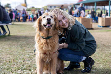 Teenage girl smiling with her golden retriever dog outside