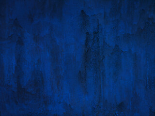 Old blue metal painted wall. Cracked paint texture. Dark blue background with paint drips.