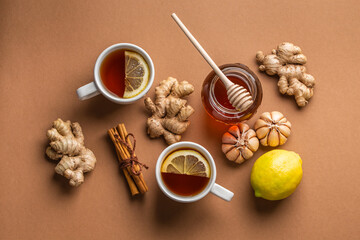 Natural cold and flu home remedies: hot tea cups with lemon, honey, ginger and garlic to boost...