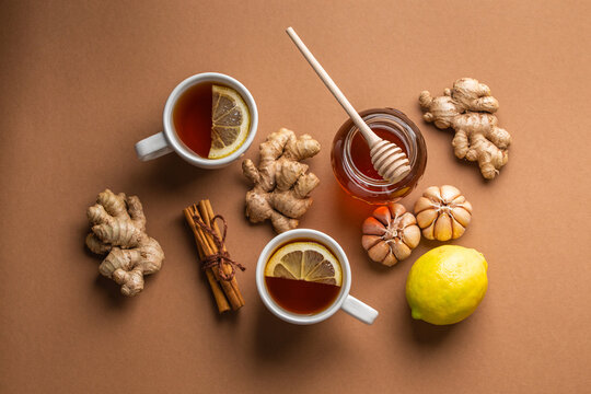 Natural Cold And Flu Home Remedies: Hot Tea Cups With Lemon, Honey, Ginger And Garlic To Boost Immune System. Natural Healthy Food Ingredients For Immunity Stimulation And Against Viruses. Top View.