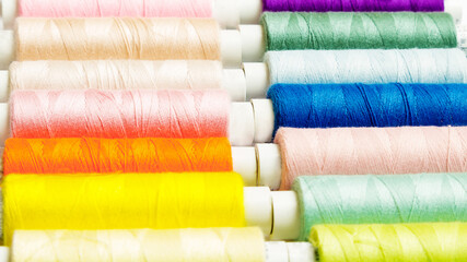 many multi-colored small spools with sewing thread.