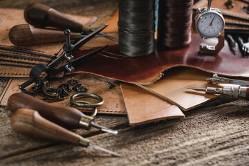 Leather craft tools on old wood table. Leather craft workshop.