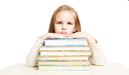 little beautiful preschooler girl sitting at a table over a pile of books tired and sad on a white background. front view.