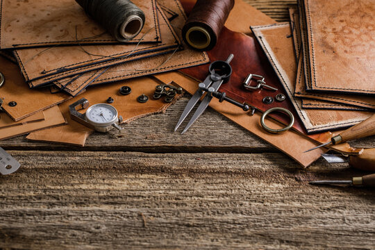 Leather craft tools on old wood table. Leather craft workshop.