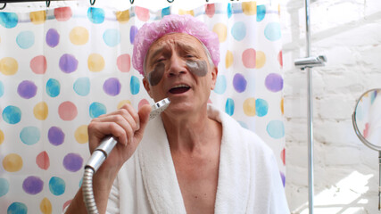 Portrait of senior man with eye pads wearing shower cap singing in bathroom
