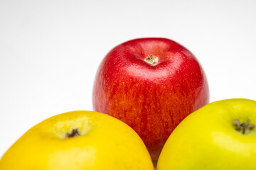 Three juicy ripe apples on a white background, close-up view.