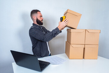 Storekeeper with a barcode reader in hand. A man accepts goods for storage. Warehouse storage. A...