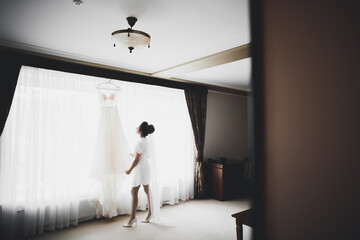 Fototapeta premium Luxury bride in white dress posing while preparing for the wedding ceremony