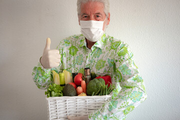 Senior man delivering food and drink in a basket for people in quarantine for Covid-19 coronavirus...