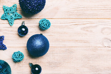 Top view of Christmas balls and creative decorations on wooden background with copy space. New Year concept