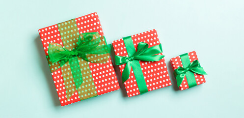 Obraz premium Top view Christmas present box with green bow on blue background