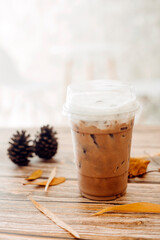 Iced caramel latte coffee in a tall glass with syrup and whipped cream.