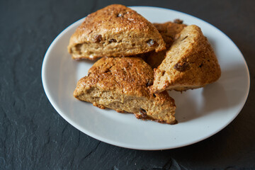 Fototapeta na wymiar Traditional fresh baked English homemade scones with raisins for breakfast. 