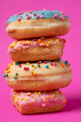 Colored donuts, on a pink background.