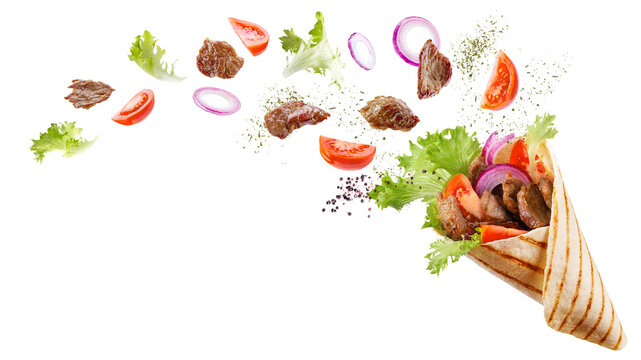 Doner kebab or shawarma with ingredients floating in the air : beef meat, lettuce, onion, tomatos, spice. White background. Copy space.