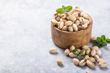 Pistachio nuts in wooden bowl. Roasted salted pistachios.