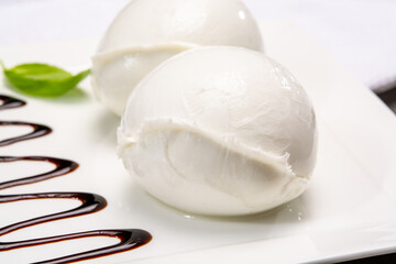 Сheese collection, balls on soft white mozzarella bufala cheese served with balsamic cream tomato and fresh basil white mozzarella bufala cheese served with balsamic cream and fresh basil