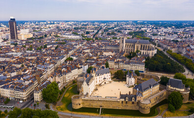 Fototapeta na wymiar Aerial view of historic area of Nantes overlooking medieval Castle of Dukes of Brittany, Gothic Roman Catholic cathedral with Tour Bretagne on background, France