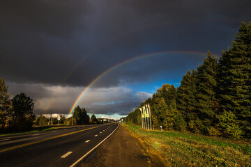 beautiful double rainbow stands over the road