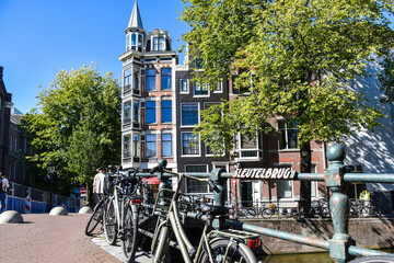 Fototapeta premium Bicycles on the'Sleutel' Bridge against a setting of historic facades in Amsterdam, the Netherlands.