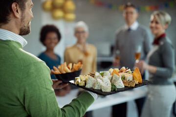 Close-up of businessman serving food during office party.