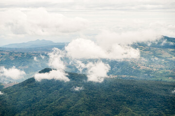 The high mountain is covered with the mostly cloudy.