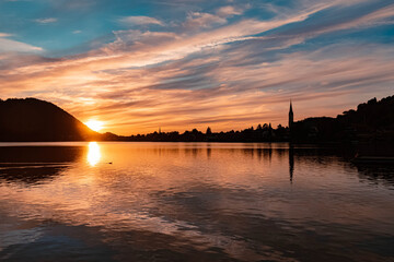 Beautiful alpine sunset view with reflections and dramatic clouds at the famous Schliersee, Bavaria, Germany