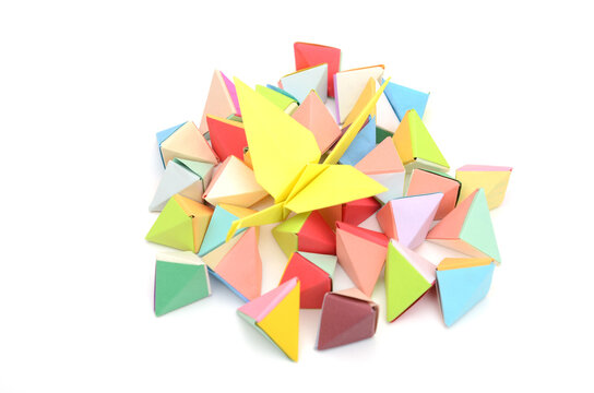 a yellow origami bird on origami tetrahedrons
