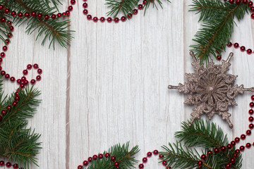 Fototapeta na wymiar fir branches and red Christmas decorations on a light wood background