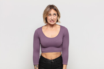 young pretty woman looking worried, stressed, anxious and scared, panicking and clenching teeth