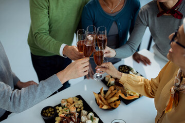 Close-up of business people toasting with Champagne on office party.