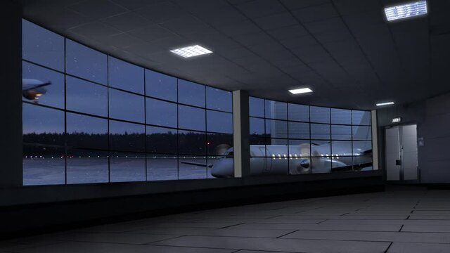 A winter vacation clip of an empty airport terminal in the night with a propeller airplane in snowfall behind window ready for boarding and a big aircraft landing in the background