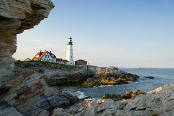 Lighthouse on the coast of Maine with rocks at sunset