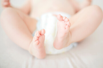 Fototapeta na wymiar Small baby girl feet on the bed