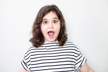 Surprised little girl looking at camera.