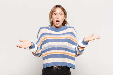 young pretty woman feeling extremely shocked and surprised, anxious and panicking, with a stressed...