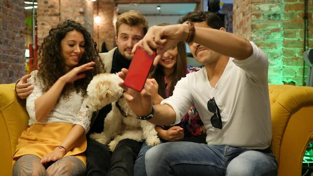 Friends with pet dog in bar take smartphone selfie picture hangout together having fun