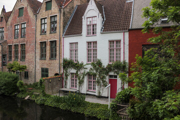 Fototapeta na wymiar Bruges, Belgium - May 12, 2018: Unique Houses Above A Water Channel