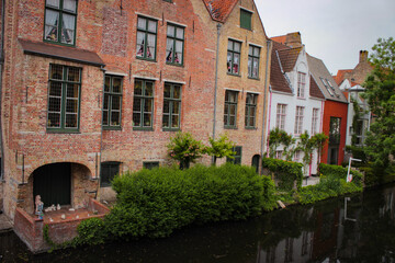 Fototapeta na wymiar Bruges, Belgium - May 12, 2018: Unique Houses Above A Water Channel