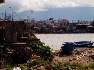 slums on the banks of the vietnam river. fishing boats.