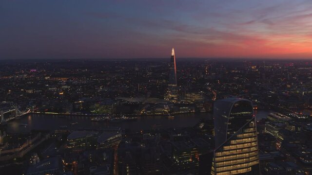Aerial night footage of London City - Aerial stock footage looking at over Tower Bridge, The Shard and The Gherkin