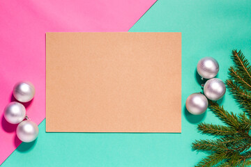 Christmas flat lay of fir branches and silver decorations on the turquoise and pink background with copy space. Image for Christmas greeting cards and articles. Winter, New Year, Christmas concept