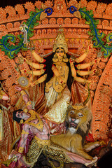 Fototapeta premium Idol of Goddess Devi Durga at a decorated puja pandal in Kolkata, West Bengal, India. Durga Puja is a popular and major religious festival of Hinduism that is celebrated throughout the world.