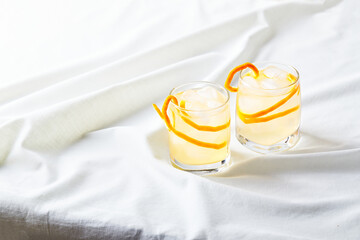 Cool refreshing alcohol cocktail decorated with orange zest