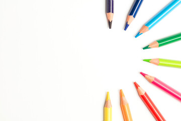 Colored pencils in a circle, white background, top view