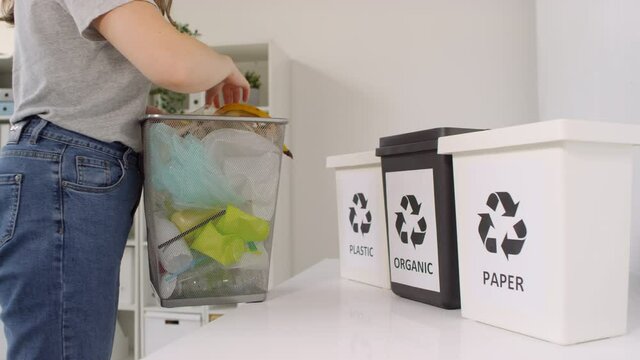 Side view midsection shot of ecology activist sorting trash bin into containers for further recycling