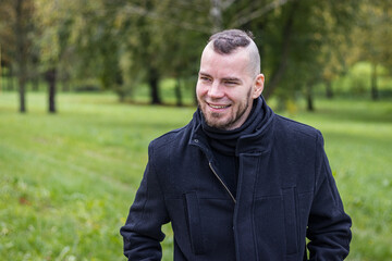 A man walks in a park and smiling